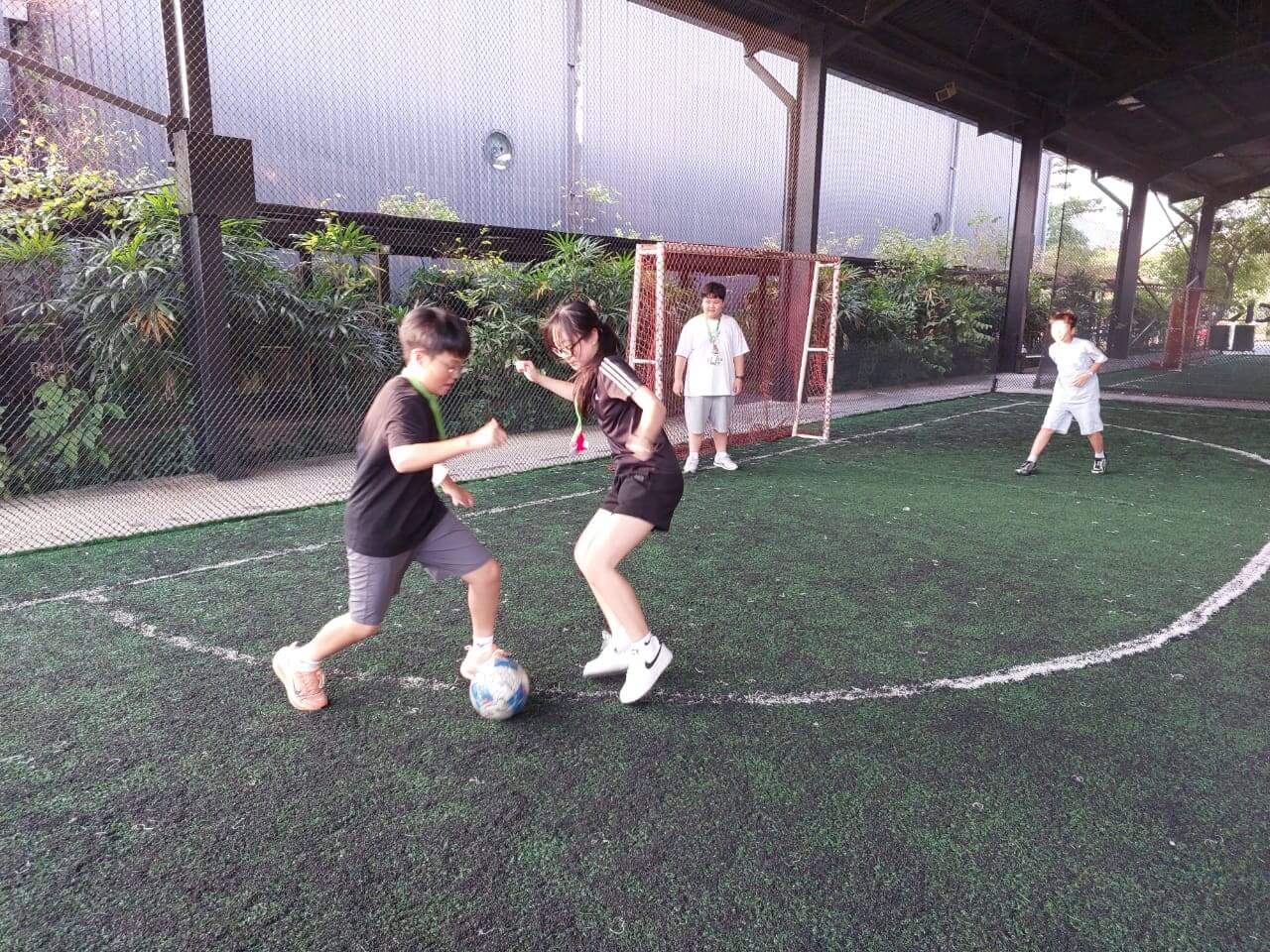 풋살장에서 축구하는 학생들